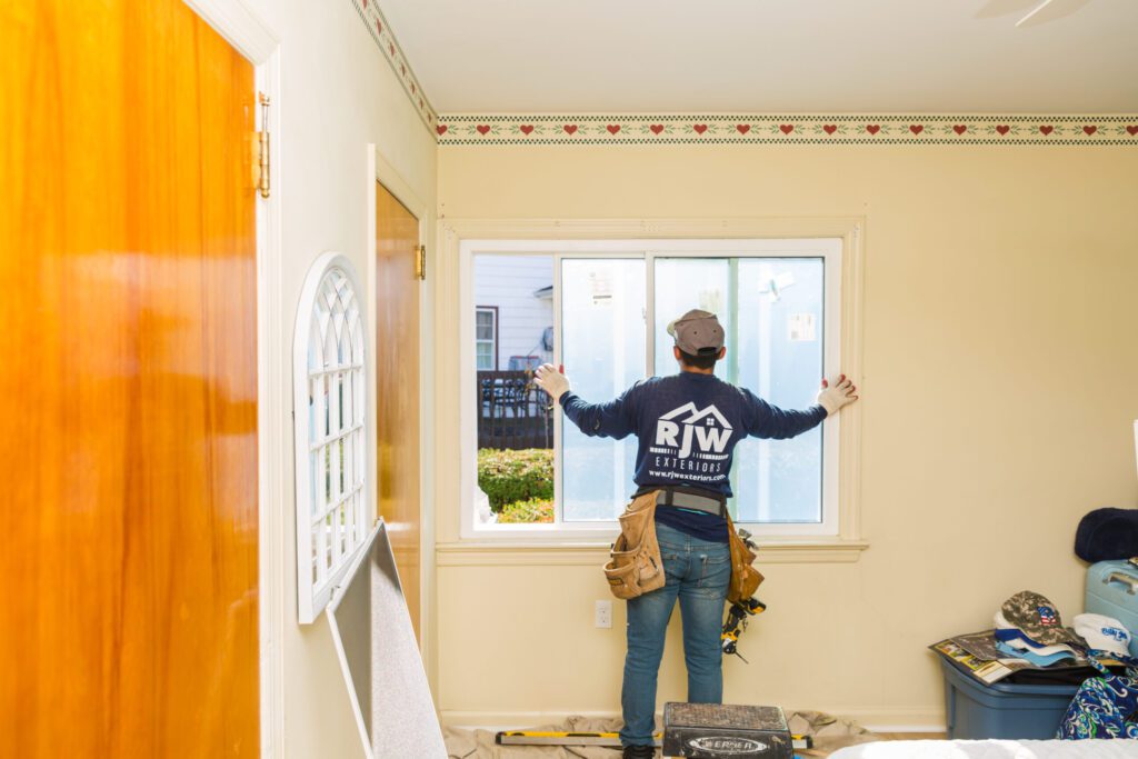 A person standing in front of a window.