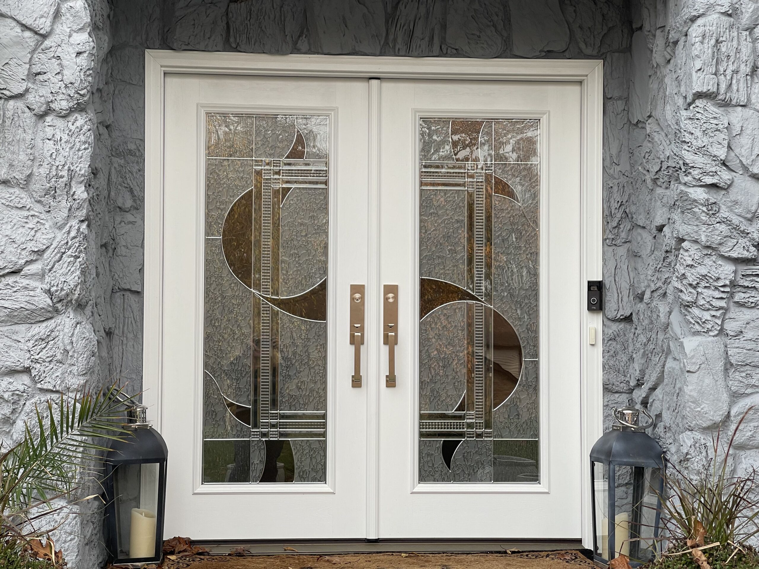 A white front door with decorative glass panels.