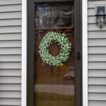 A front door with a wreath on it.
