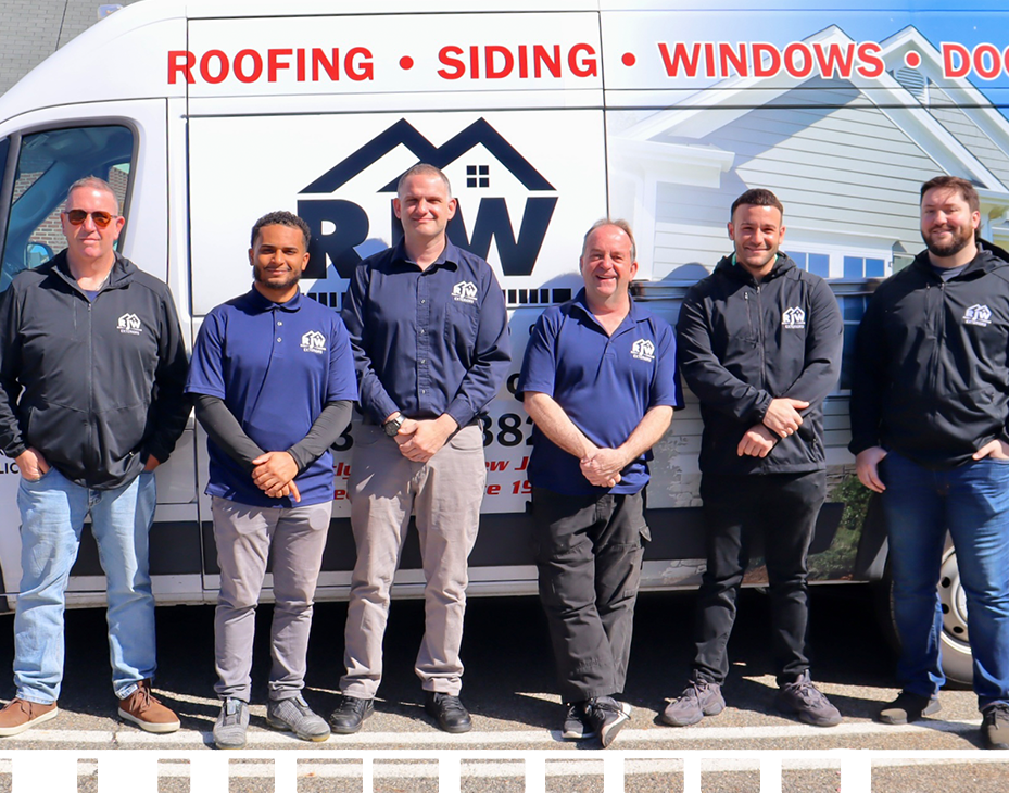 Five workers in uniforms standing in front of a company van labeled "roofing, siding, windows, doors.