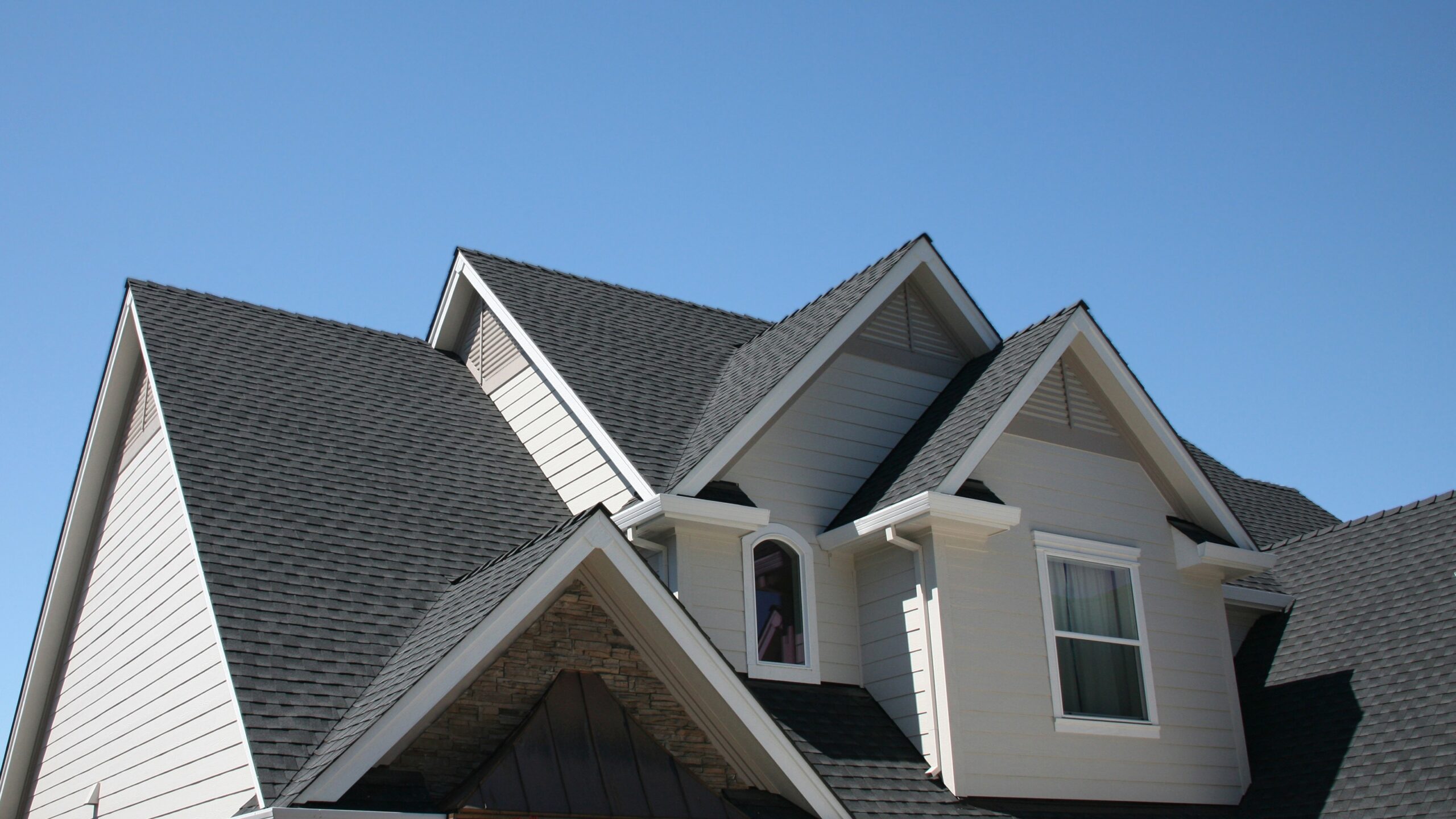 A home with white siding and a gray shingle roof