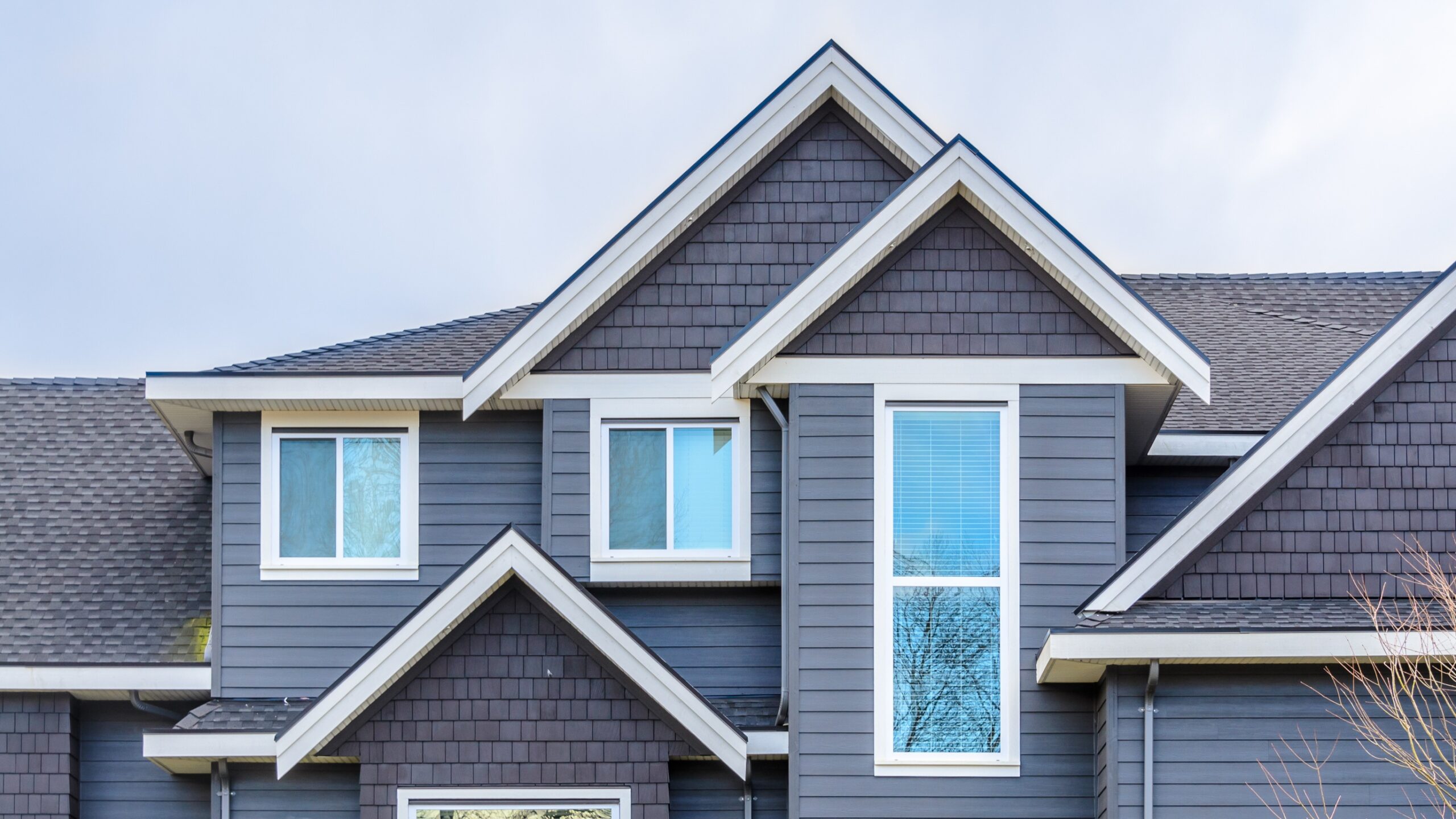 A gray-sided home with white-framed windows