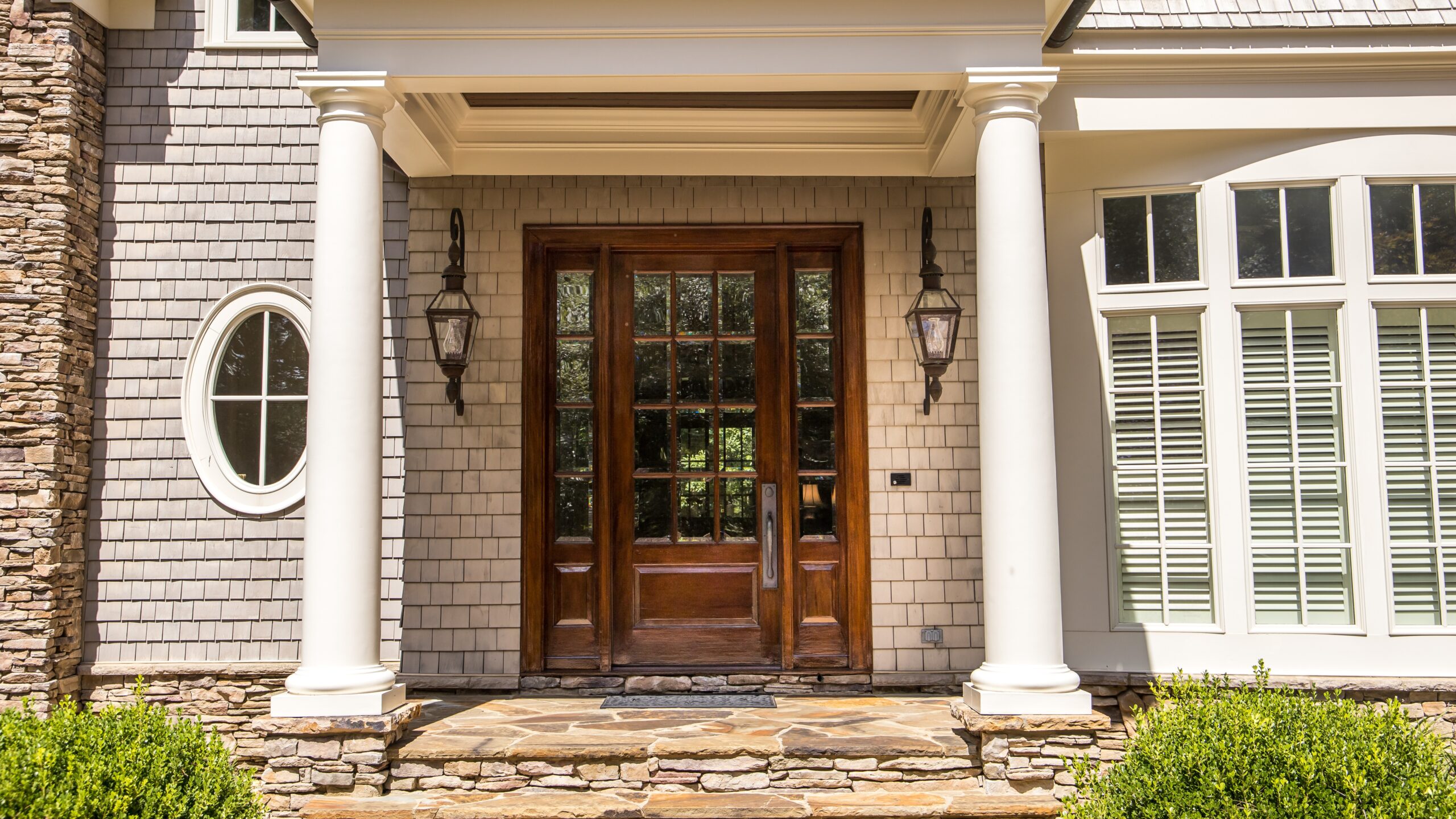 A home with brown siding, white trim, and a brown entry door