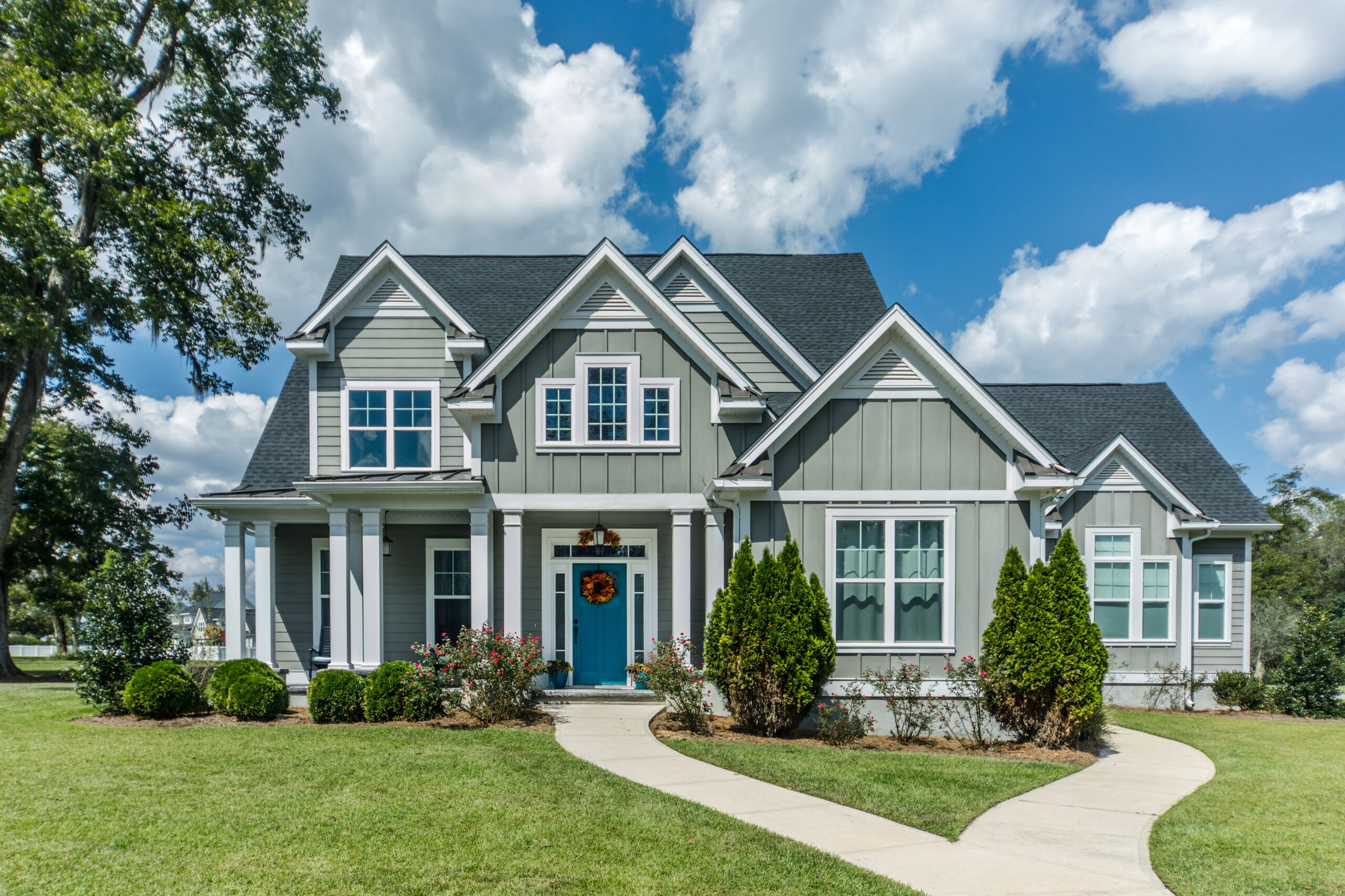 Beautiful large home with green siding and white windows