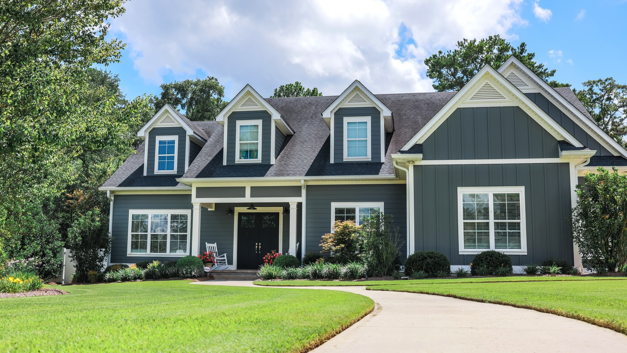 Wide view of a beautiful blue suburban home with a freshly done exterior