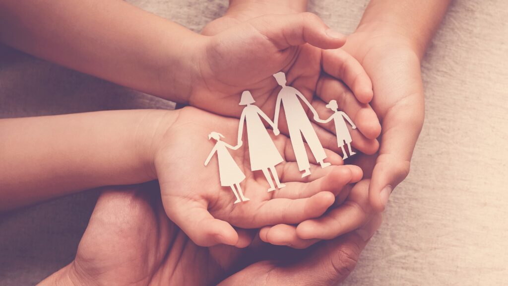 Adult and child's hands holding family cutouts - promoting safe, durable roofing solutions