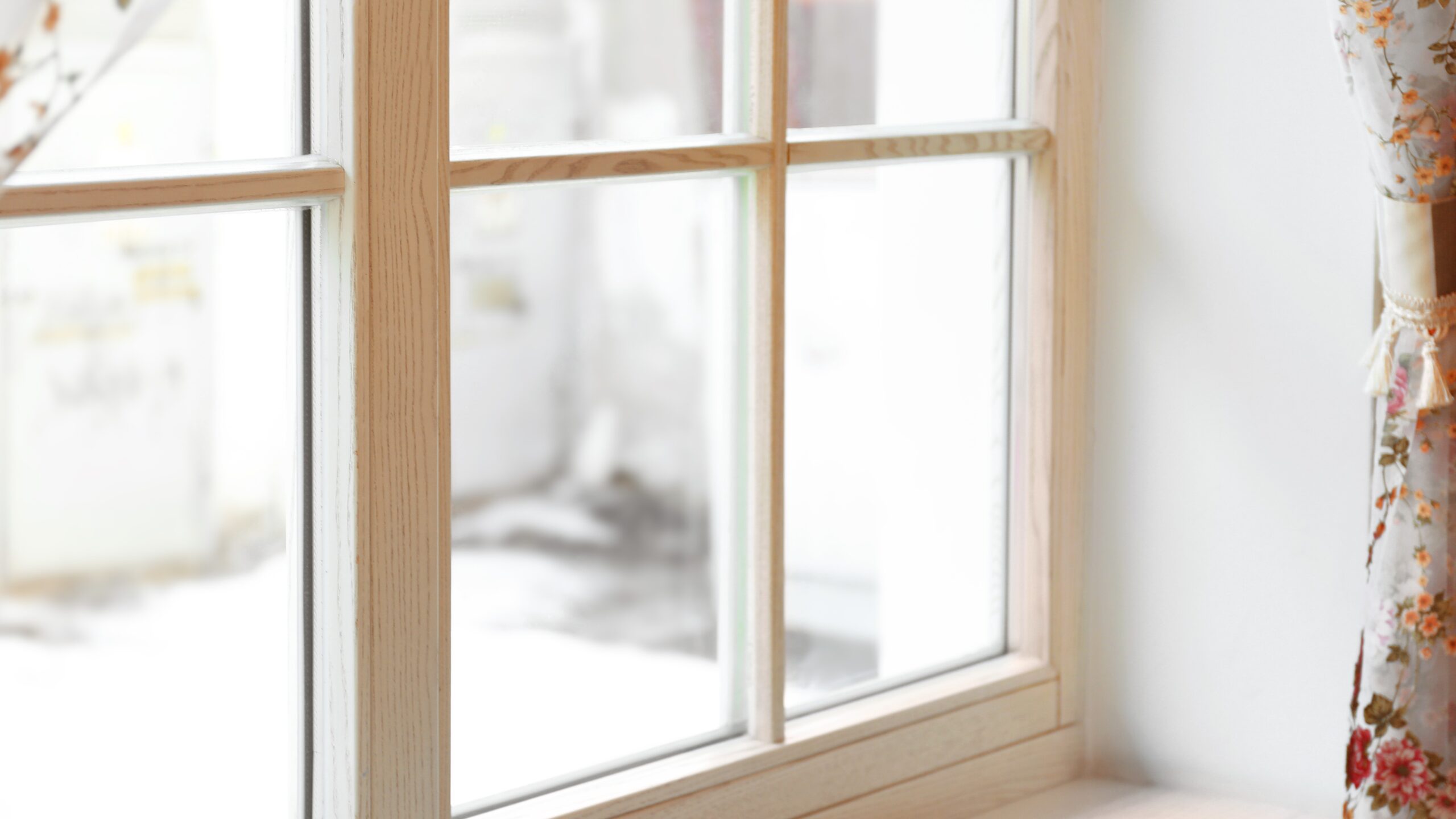 A view of an outdoor space through the corner of a new wooden window