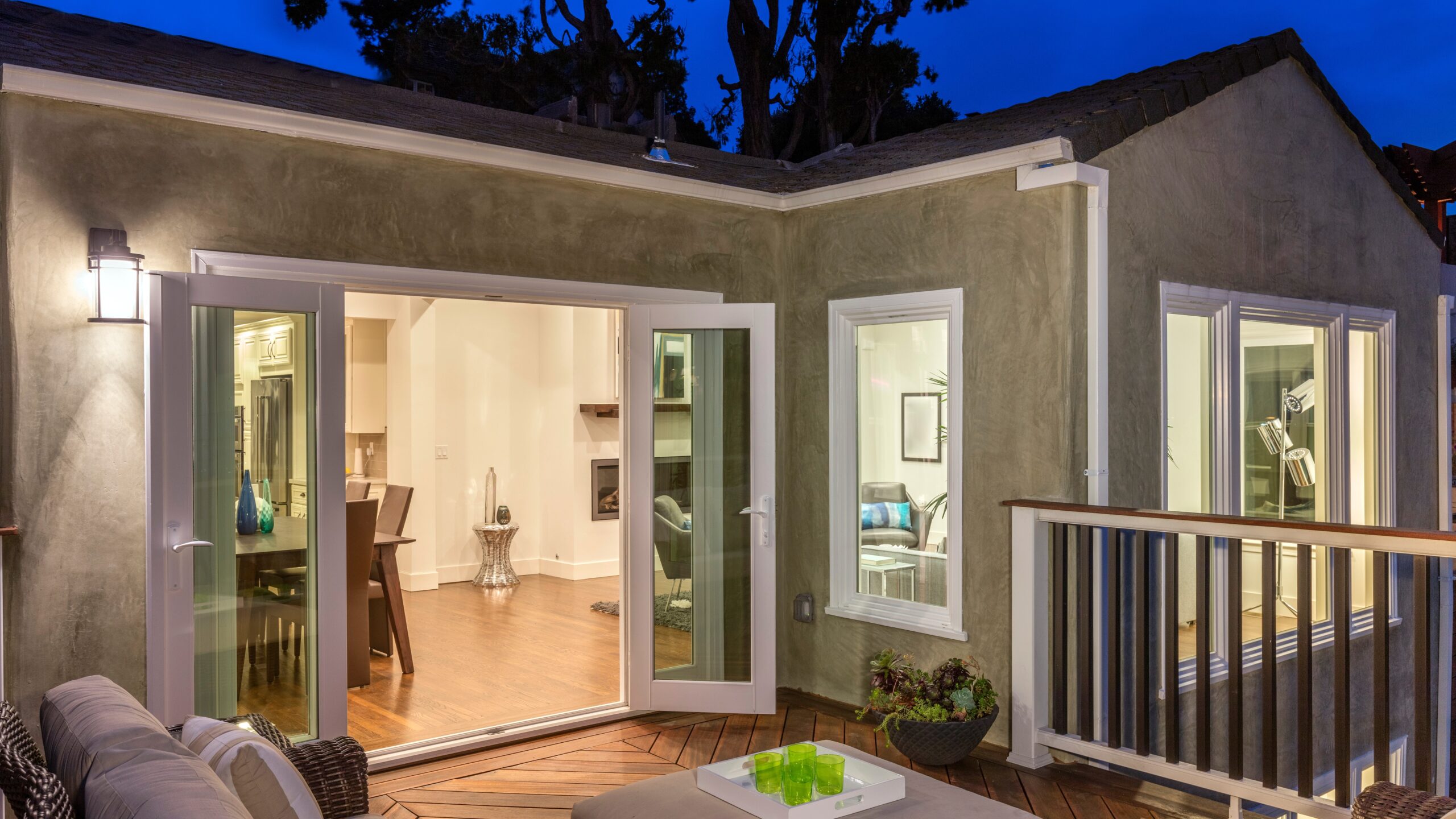 View of a small patio with open hinged doors leading to a home’s interior