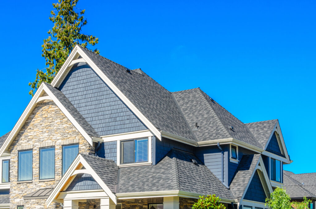 There is a dark gray roof on a dark blue home