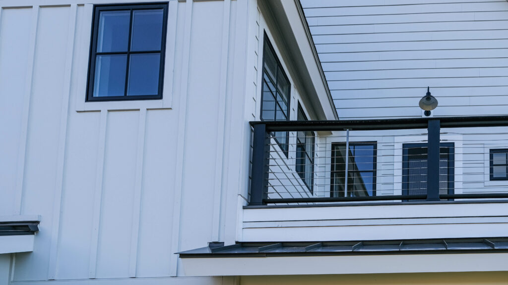 Angled detail of a white house with multiple forms of Hardie Board siding installed