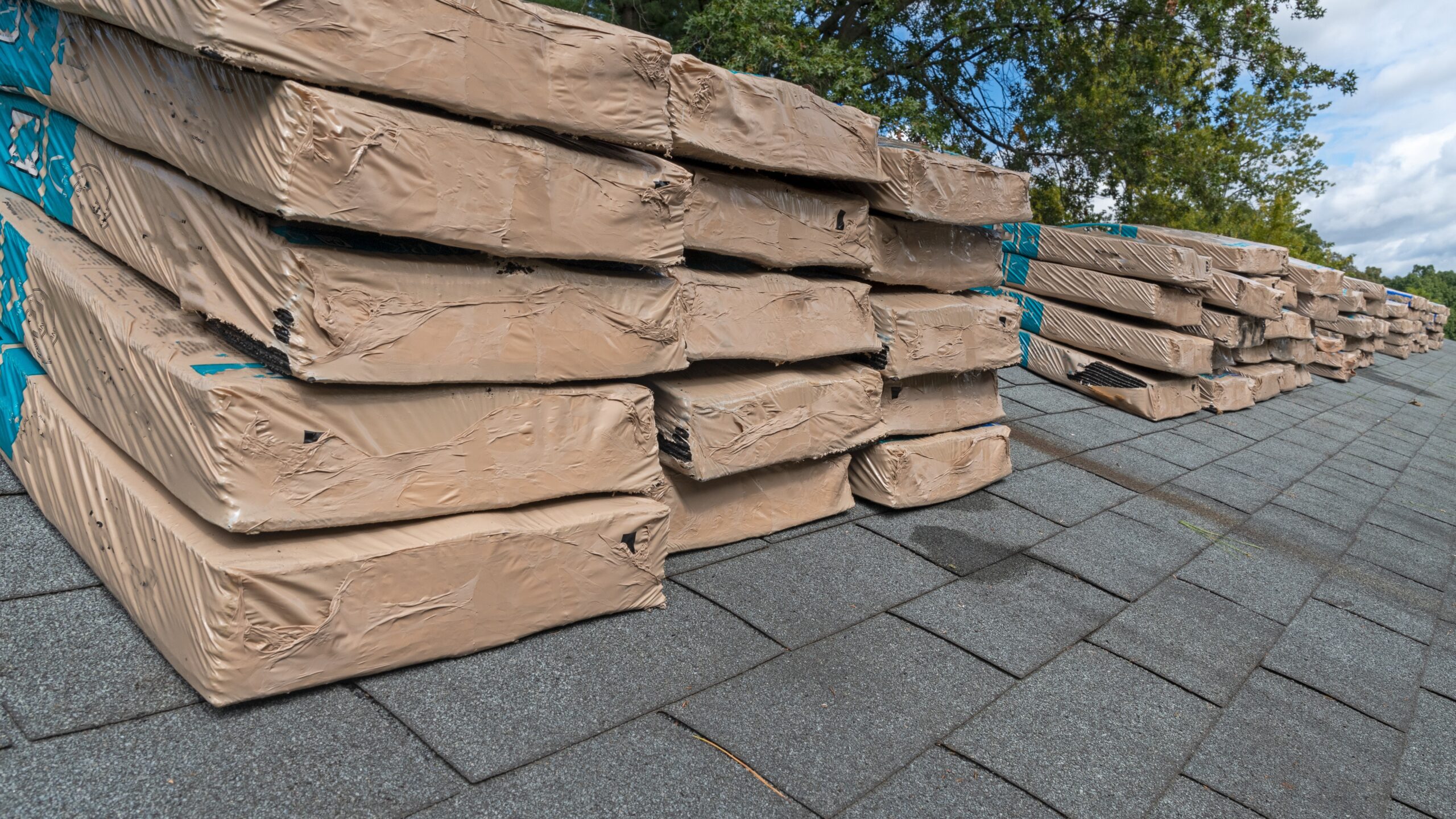 Close view of stacks of shingles on a roof about to undergo replacment