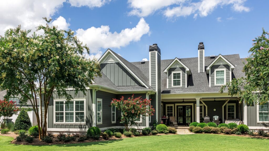 Angled frontal view of a beautiful green/gray suburban home clad in James Hardie siding