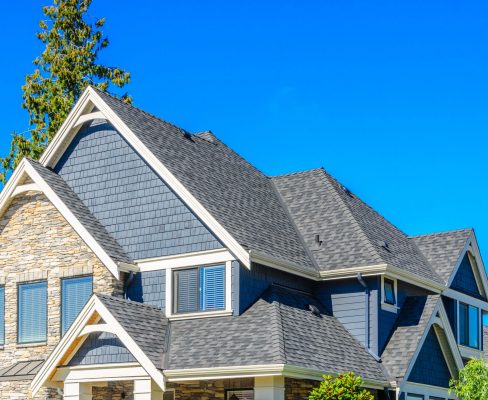 There is a dark gray roof on a dark blue home