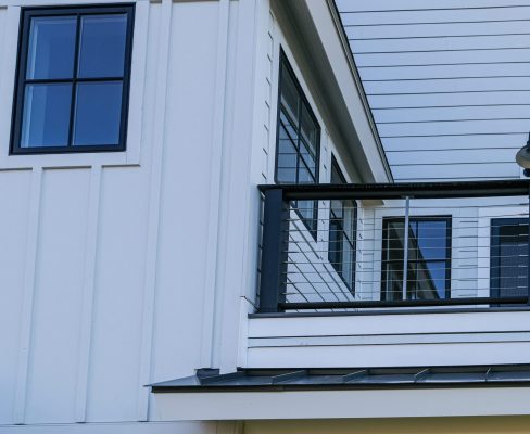 Angled detail of a white house with multiple forms of Hardie Board siding installed