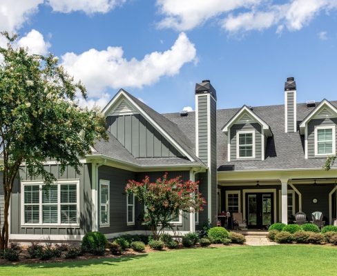 Angled frontal view of a beautiful green/gray suburban home clad in James Hardie siding